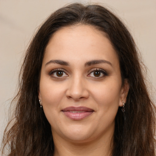 Joyful latino young-adult female with long  brown hair and brown eyes