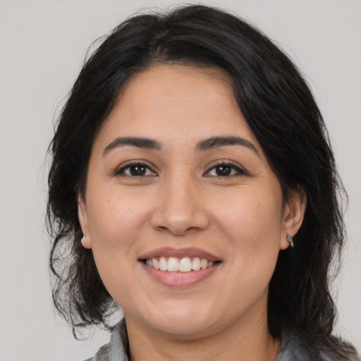 Joyful latino young-adult female with medium  brown hair and brown eyes