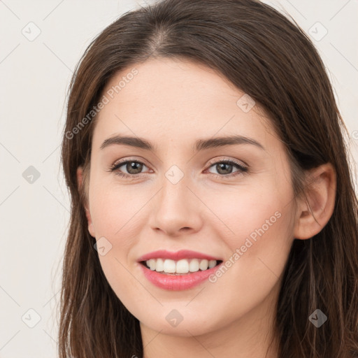 Joyful white young-adult female with long  brown hair and brown eyes