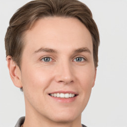 Joyful white young-adult male with short  brown hair and grey eyes