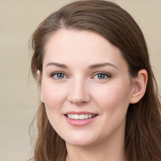 Joyful white young-adult female with long  brown hair and grey eyes