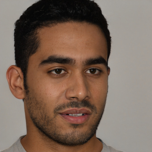 Joyful latino young-adult male with short  black hair and brown eyes