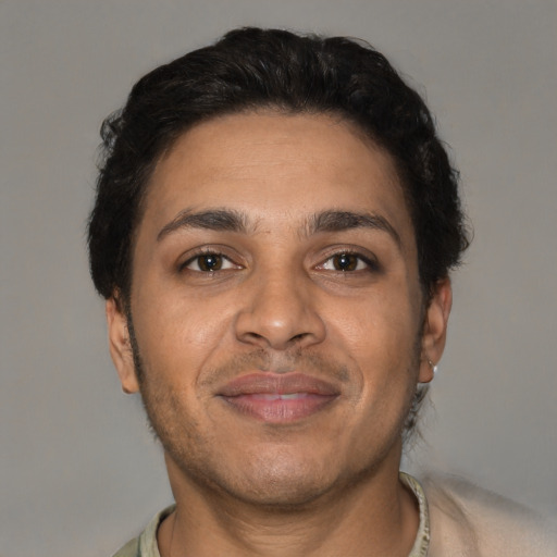 Joyful latino adult male with short  brown hair and brown eyes