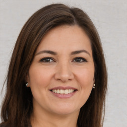 Joyful white young-adult female with long  brown hair and brown eyes