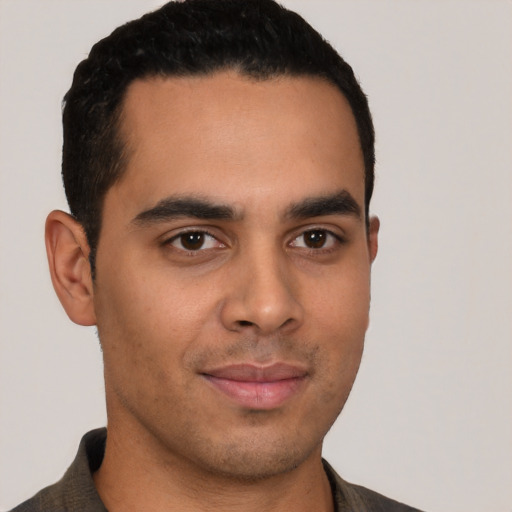 Joyful latino young-adult male with short  brown hair and brown eyes