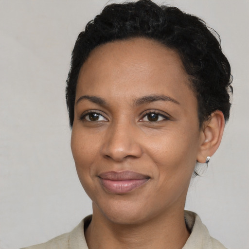 Joyful black young-adult female with short  black hair and brown eyes