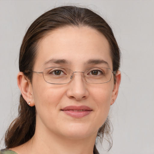 Joyful white young-adult female with medium  brown hair and grey eyes