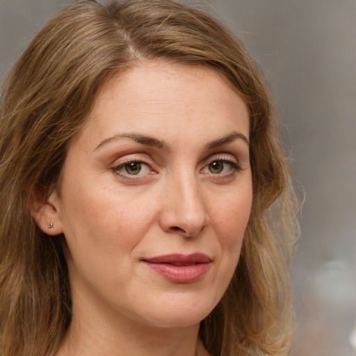 Joyful white adult female with medium  brown hair and green eyes