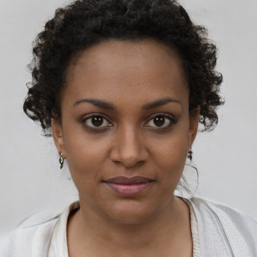 Joyful black young-adult female with short  brown hair and brown eyes