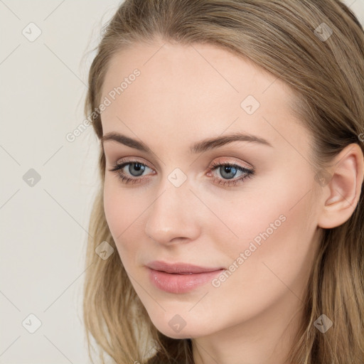 Joyful white young-adult female with long  brown hair and blue eyes