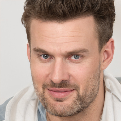 Joyful white adult male with short  brown hair and brown eyes