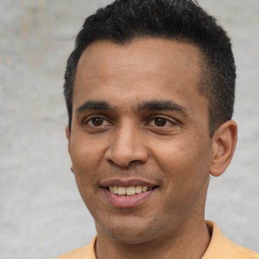 Joyful latino young-adult male with short  black hair and brown eyes