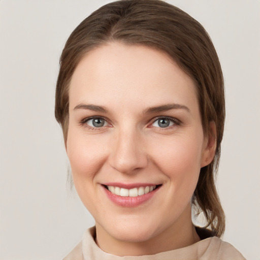 Joyful white young-adult female with medium  brown hair and grey eyes