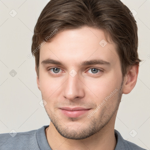 Joyful white young-adult male with short  brown hair and grey eyes