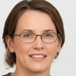 Joyful white adult female with medium  brown hair and grey eyes