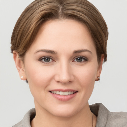 Joyful white young-adult female with short  brown hair and grey eyes