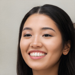 Joyful latino young-adult female with long  black hair and brown eyes