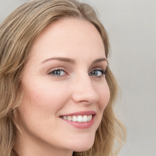 Joyful white young-adult female with long  brown hair and blue eyes