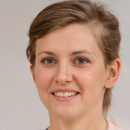 Joyful white young-adult female with medium  brown hair and grey eyes