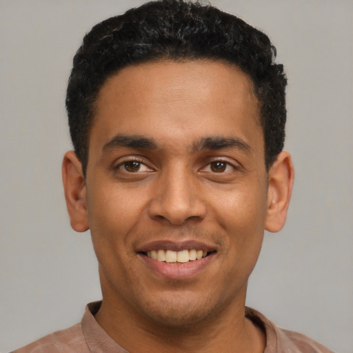 Joyful latino young-adult male with short  black hair and brown eyes