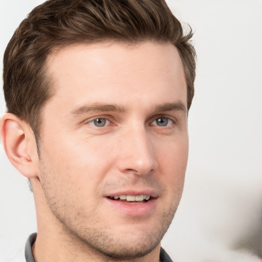 Joyful white young-adult male with short  brown hair and grey eyes