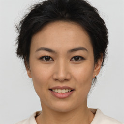 Joyful asian young-adult female with short  brown hair and brown eyes