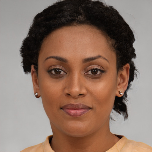 Joyful black young-adult female with short  brown hair and brown eyes