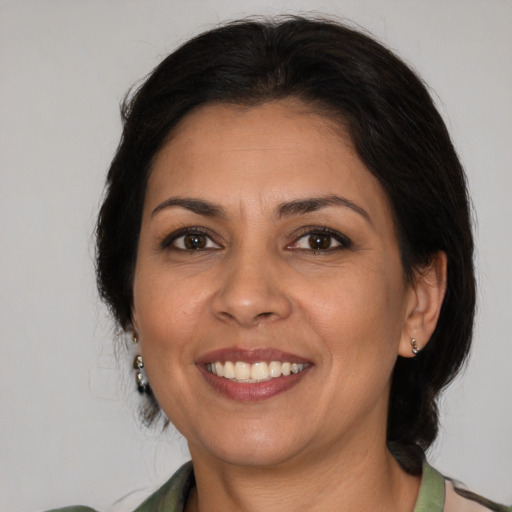 Joyful latino adult female with medium  brown hair and brown eyes