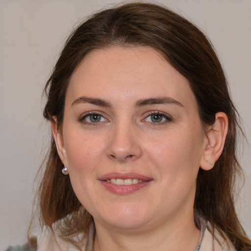 Joyful white young-adult female with medium  brown hair and grey eyes