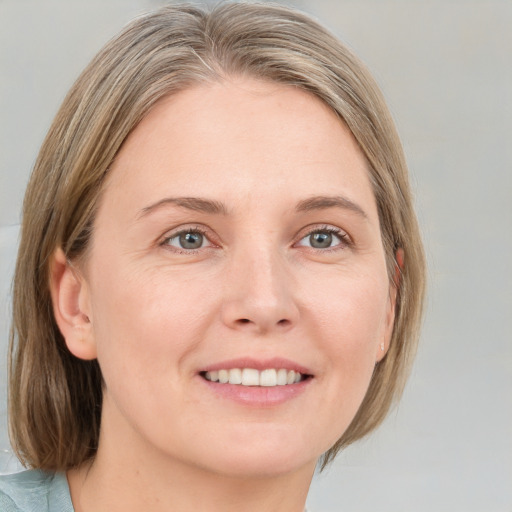 Joyful white adult female with medium  brown hair and grey eyes