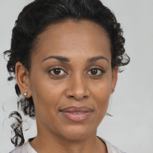 Joyful black adult female with medium  brown hair and brown eyes