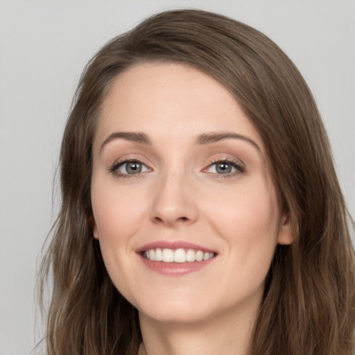 Joyful white young-adult female with long  brown hair and grey eyes