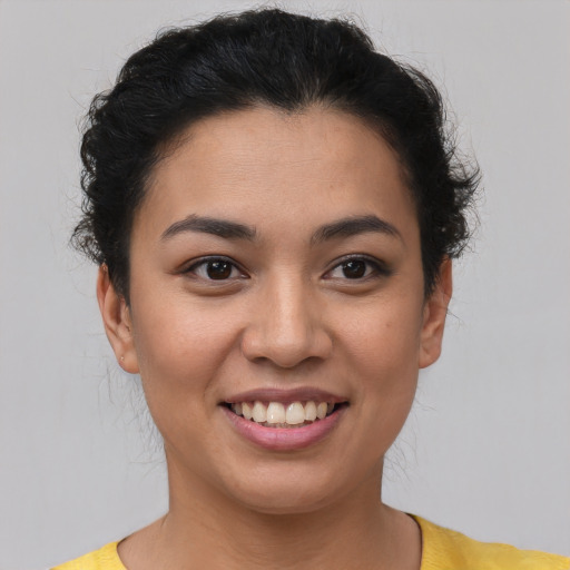Joyful latino young-adult female with short  brown hair and brown eyes