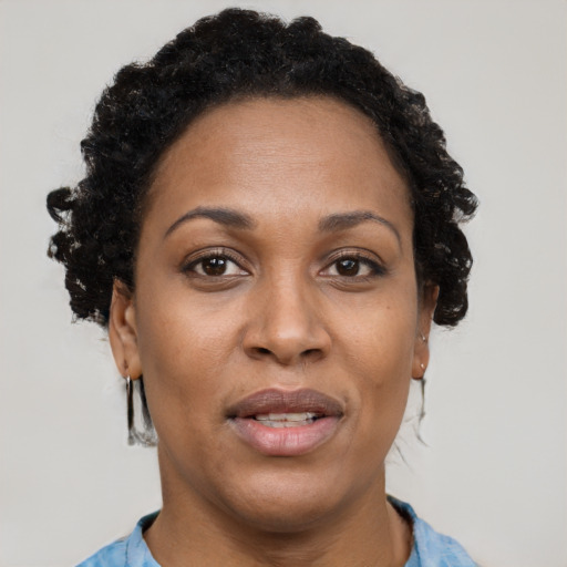 Joyful black adult female with short  brown hair and brown eyes