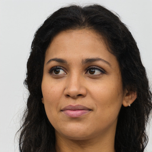 Joyful latino adult female with long  brown hair and brown eyes