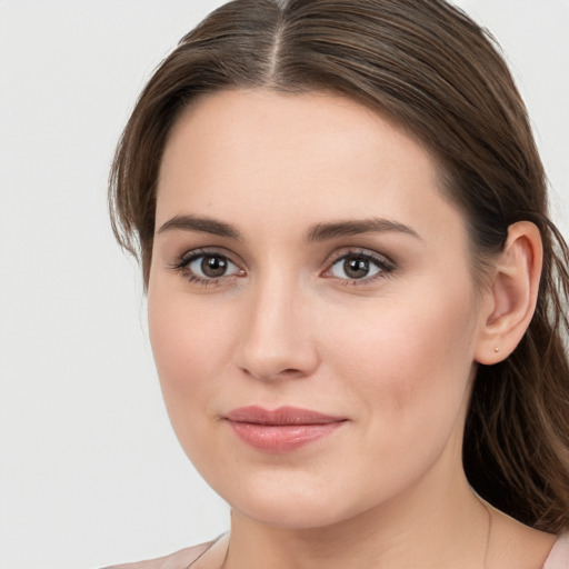 Joyful white young-adult female with long  brown hair and blue eyes