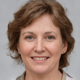 Joyful white adult female with medium  brown hair and grey eyes