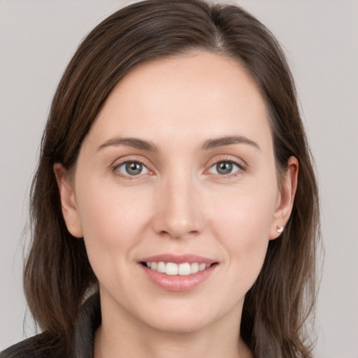 Joyful white young-adult female with long  brown hair and grey eyes