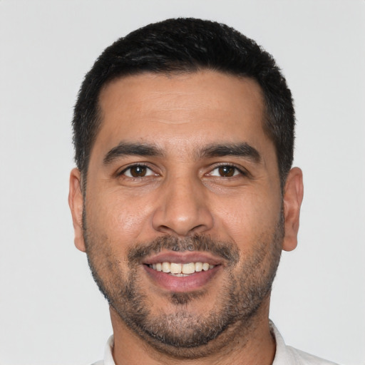 Joyful latino young-adult male with short  black hair and brown eyes