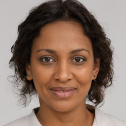 Joyful black adult female with medium  brown hair and brown eyes