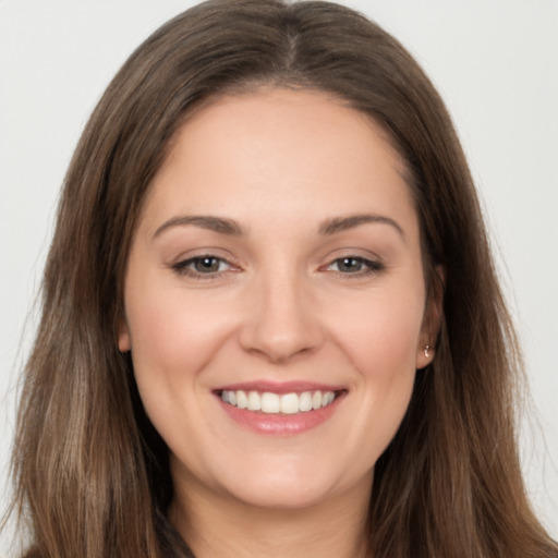 Joyful white young-adult female with long  brown hair and brown eyes