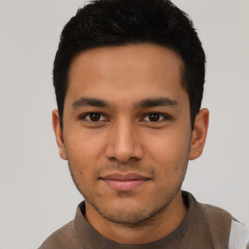 Joyful latino young-adult male with short  black hair and brown eyes