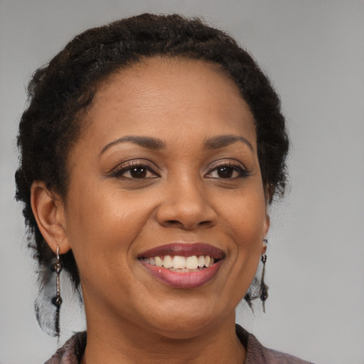 Joyful black adult female with long  brown hair and brown eyes