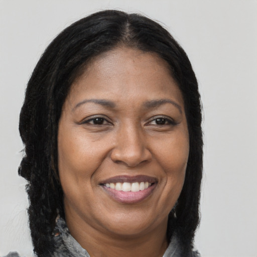 Joyful black adult female with long  brown hair and brown eyes