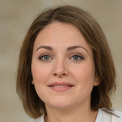 Joyful white young-adult female with medium  brown hair and green eyes