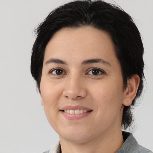Joyful white young-adult female with medium  black hair and brown eyes