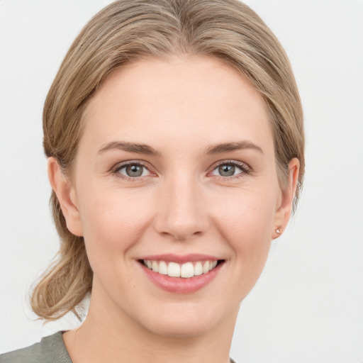 Joyful white young-adult female with medium  brown hair and grey eyes