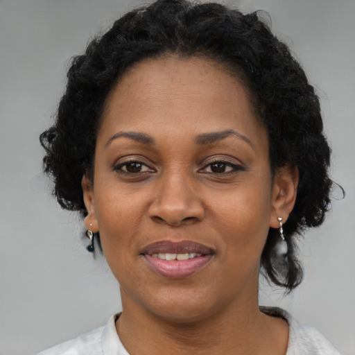 Joyful black adult female with short  brown hair and brown eyes