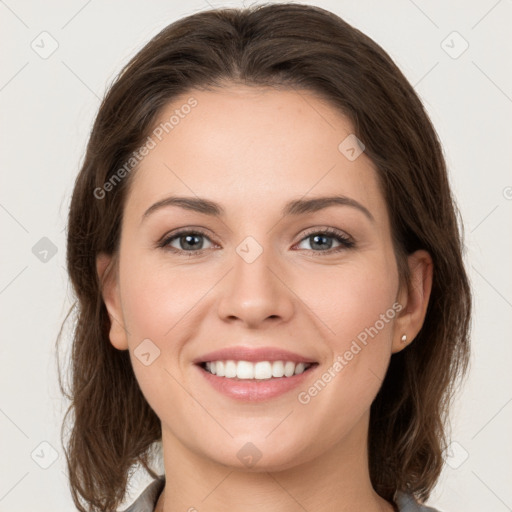 Joyful white young-adult female with medium  brown hair and grey eyes