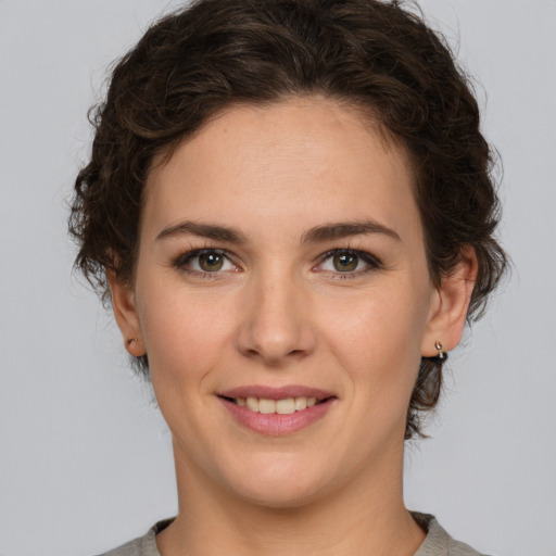 Joyful white young-adult female with medium  brown hair and green eyes